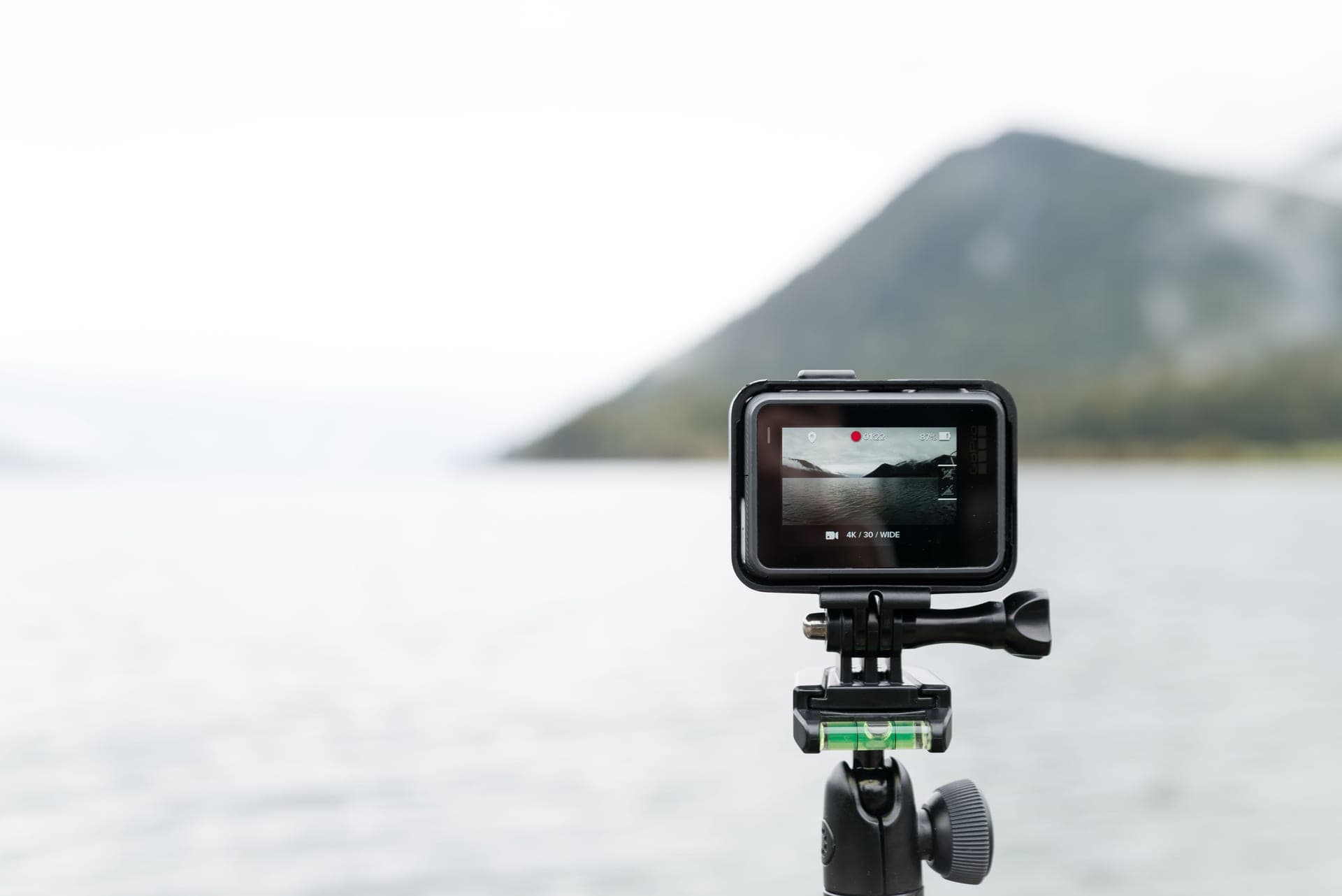 A close-up of an action camera filming a lake