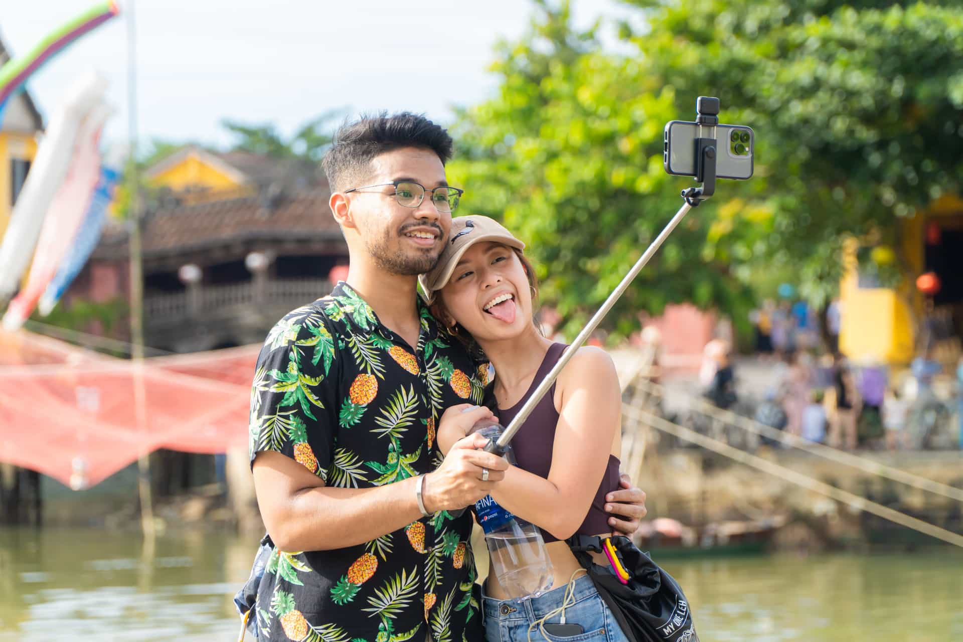 Two people taking a photo with a selfie stick outdoors